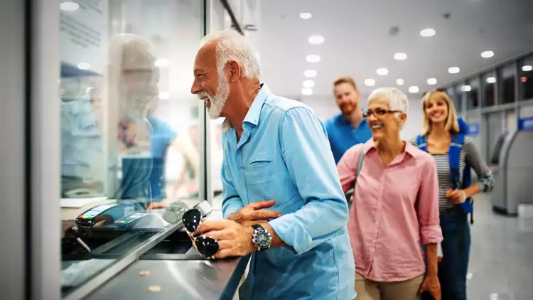 A happy elderly couple validating tickets at an airport